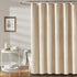 Rideau de douche beige effet lin dans une salle de bain avec tabouret