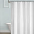 Rideau de douche blanc uni sur tringle dans une salle de bain claire